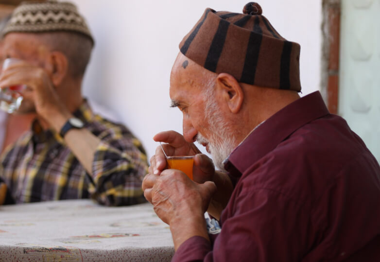 友人とお茶を飲む男性の写真