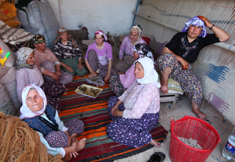 円になって座る織り手の人々の写真